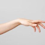 Female hand touching on gray background