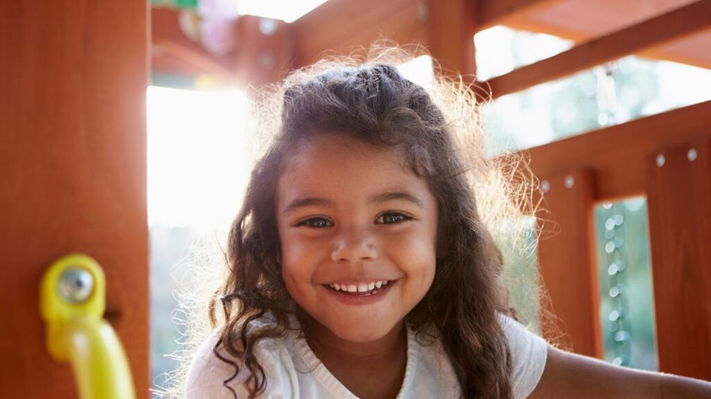 Young Hispanic girl playing on a climbing frame